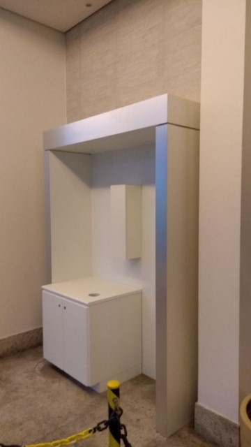 Pórtico em MDF branco com frente em fórmica stell silver, com suporte de copo e armário para máquina de café.