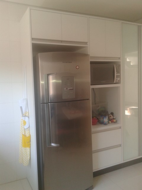 Armário de cozinha em MDF branco na parte interna e externa, com puxador de alumínio embutido, tipo cava, com 2 portas de giro com caixilho de alumínio e vidro branco leitoso.